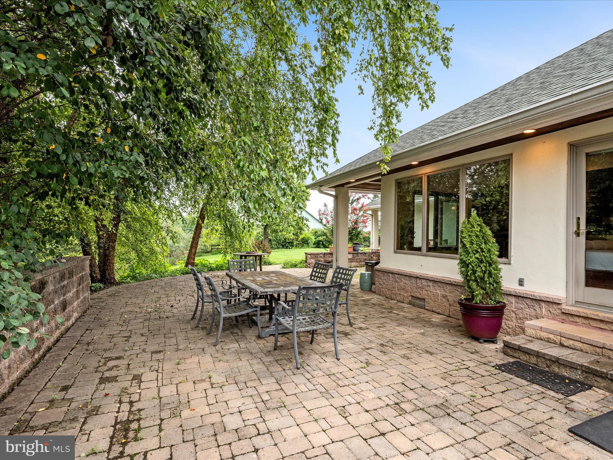 3959 Cobbler Mountain Road Delaplane, VA 20144 - Photo 63 of 106 a view of a patio with table and chairs potted plants and large tree
