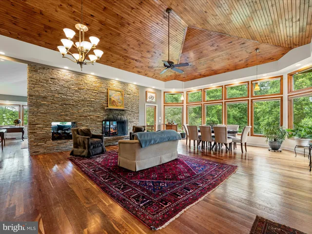 a living room with furniture a large window and wooden floor