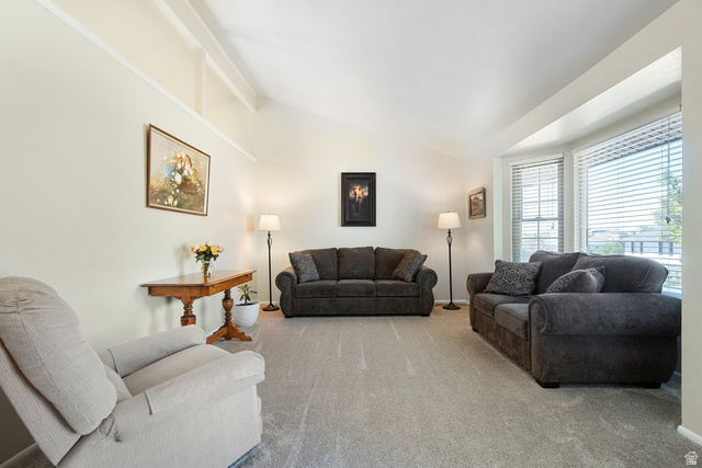 865 South 325 West Orem, UT 84058 - Photo 7 of 38 Spacious living area featuring a vaulted ceiling with exposed beams, light-colored walls, and neutral carpeting