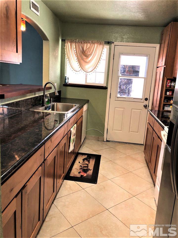 5220 Ural Street Reno, NV 89506 - Photo 8 of 19 a kitchen with granite countertop a sink a stove and a microwave