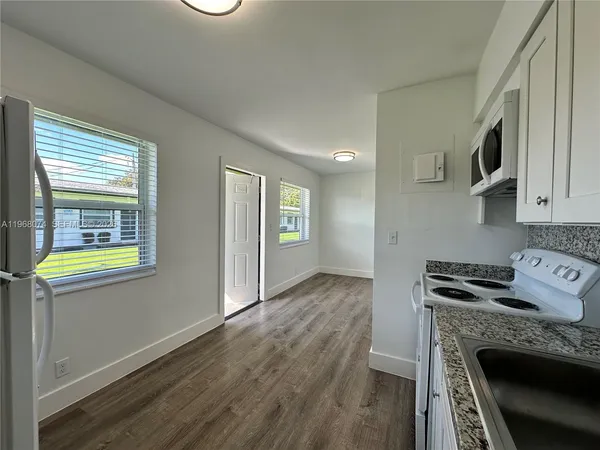 a kitchen with granite countertop a stove and a wooden floor
