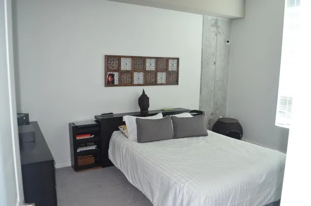 a bedroom with a bed and a wall painting