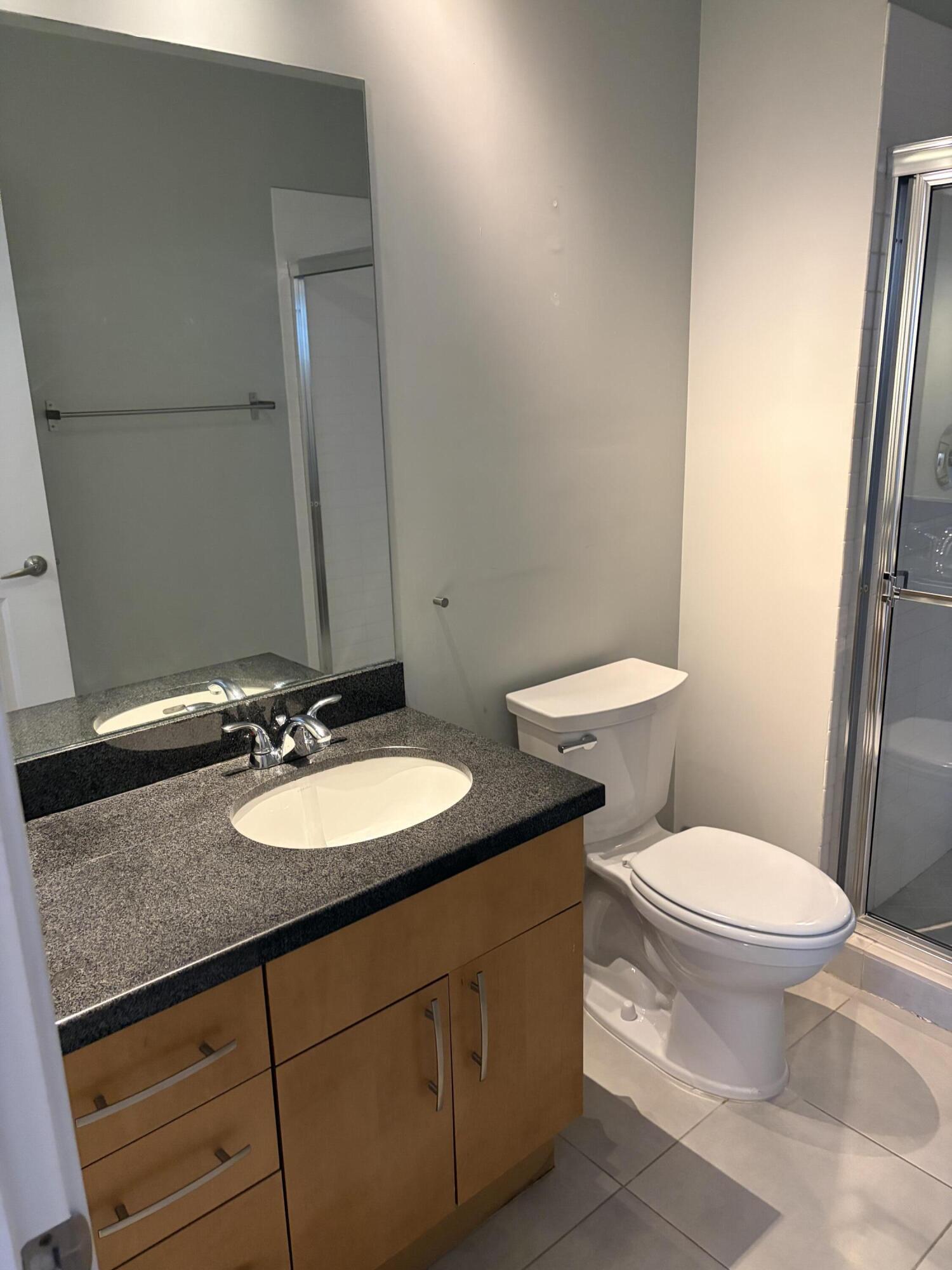 300 South Australian Avenue, Unit 1504 West Palm Beach, FL 33401 - Photo 21 of 27 a bathroom with a granite countertop toilet sink and mirror