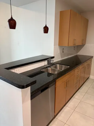 a kitchen with a sink and a wooden floor