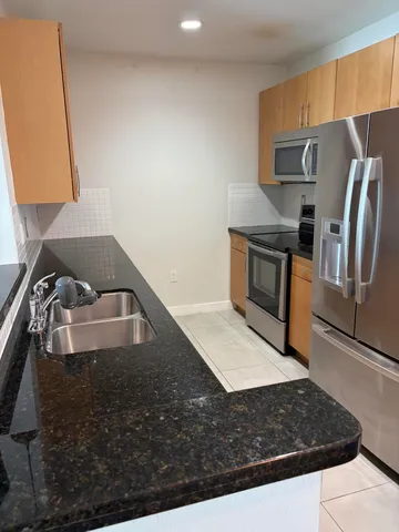 a view of kitchen island wooden floor sink and stove