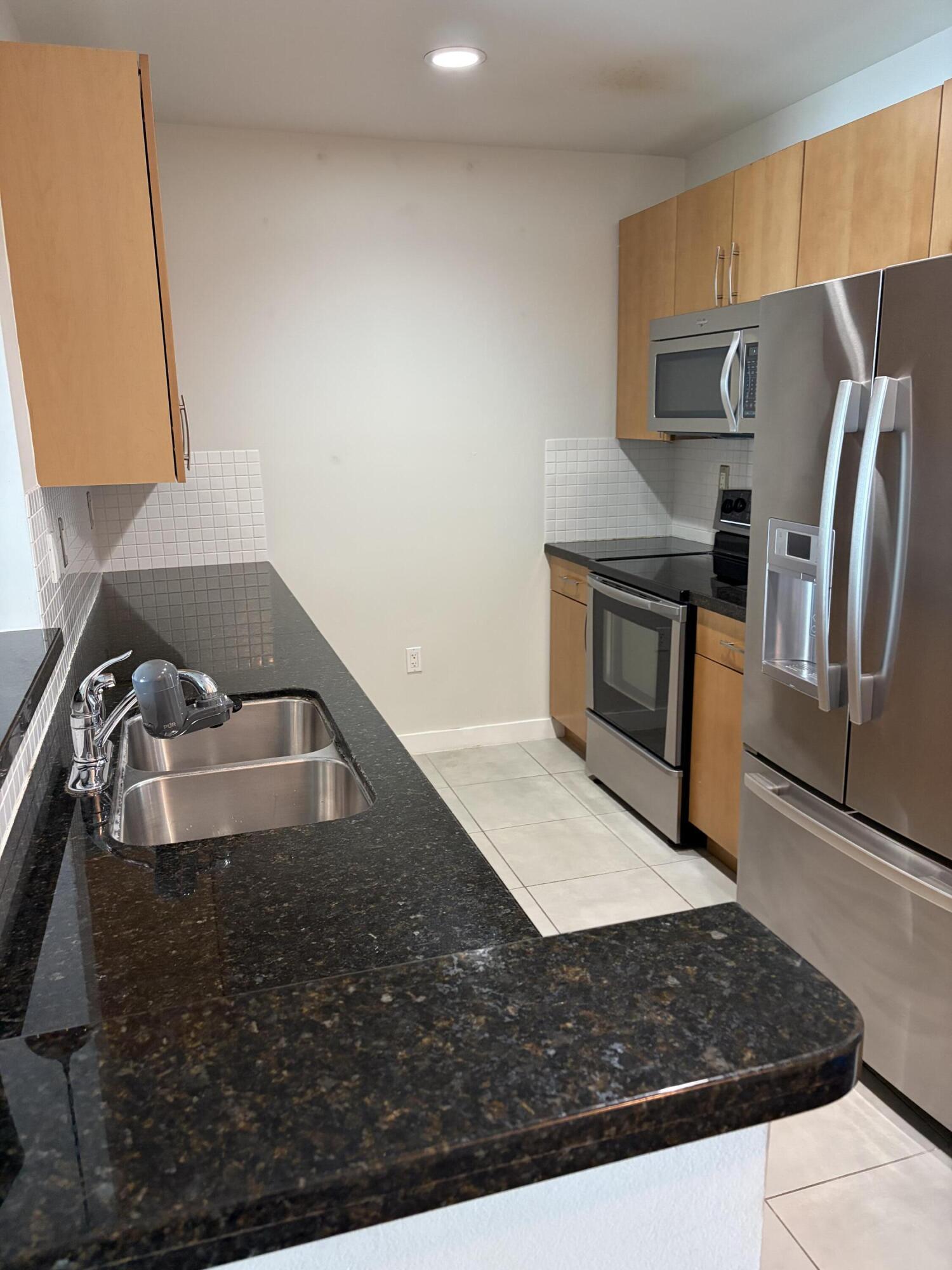 300 South Australian Avenue, Unit 1504 West Palm Beach, FL 33401 - Photo 26 of 27 a view of kitchen island wooden floor sink and stove