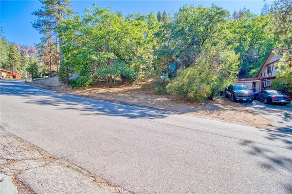 a view of a street with a building and trees in the background