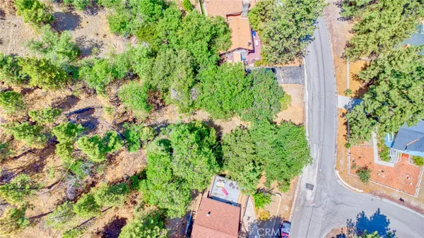 an aerial view of residential house with outdoor space and trees all around