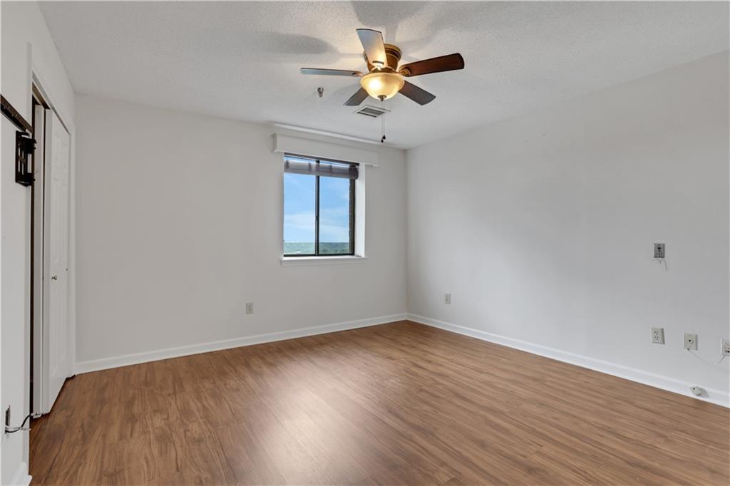 300 Johnson Ferry Road, Unit B1002 Sandy Springs, GA 30328 - Photo 13 of 26 a view of an empty room with wooden floor and a window