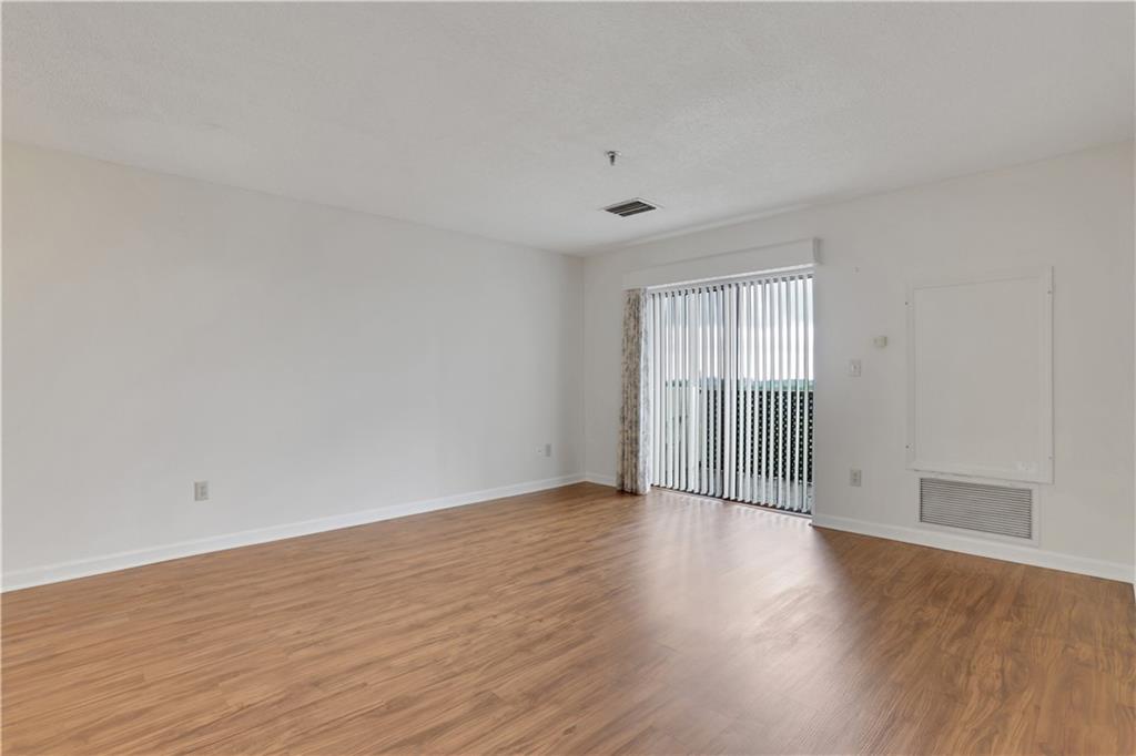 300 Johnson Ferry Road, Unit B1002 Sandy Springs, GA 30328 - Photo 7 of 26 a view of an empty room with wooden floor and a window