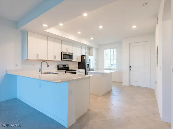 a kitchen with white cabinets and white appliances