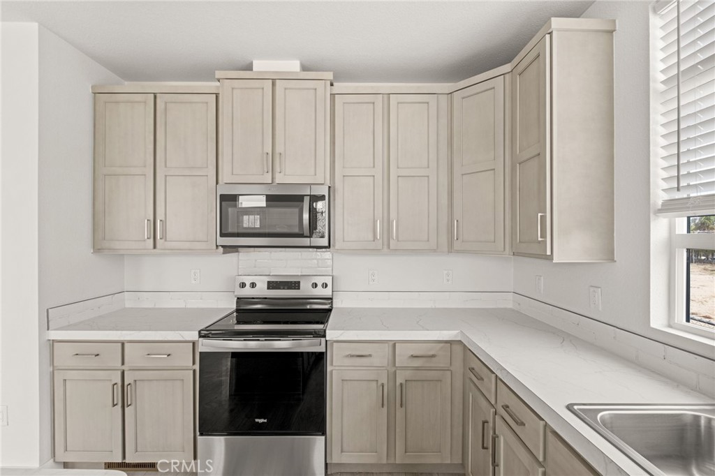 33064 Willard Street Winchester, CA 92596 - Photo 13 of 34 a kitchen with white cabinets and a stove with a sink
