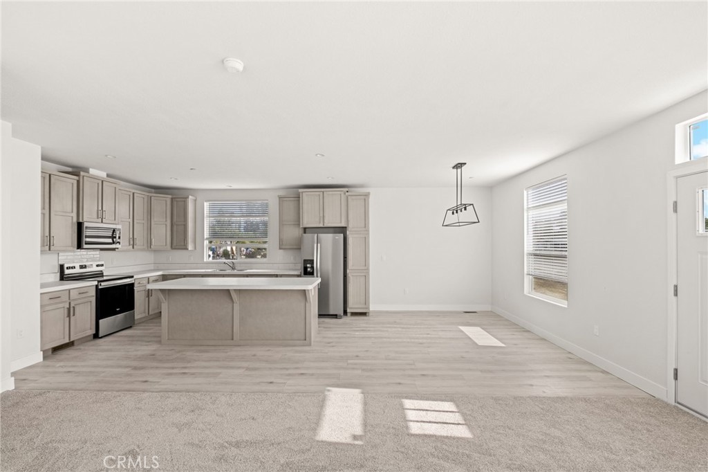 33064 Willard Street Winchester, CA 92596 - Photo 22 of 34 a large white kitchen with a stove a sink dishwasher and a refrigerator with wooden floor