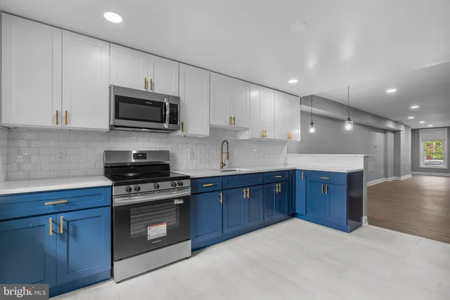 a kitchen with stainless steel appliances a stove sink microwave and cabinets