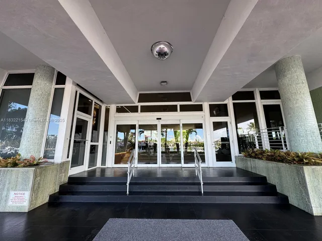 a view of staircase with lots of frames on wall and a large window