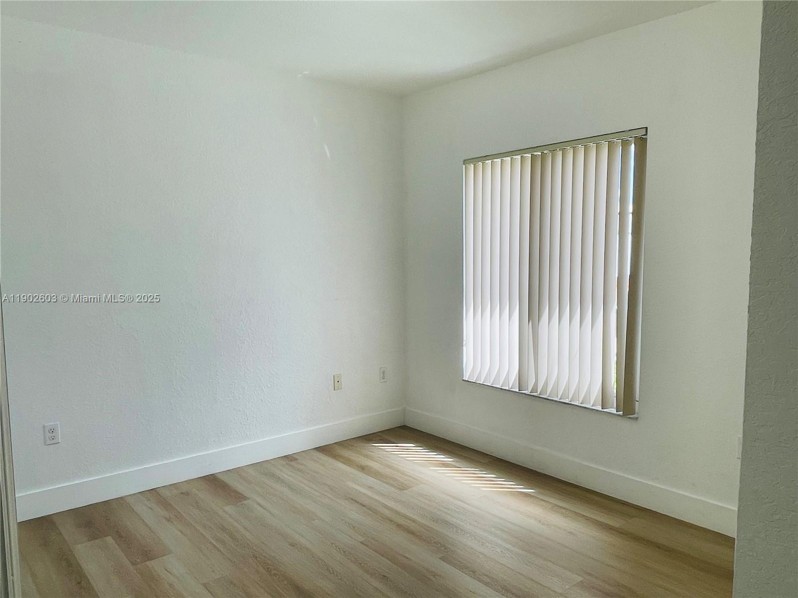 1370 West 30th Street, Unit 1370 Hialeah, FL 33012 - Photo 17 of 23 an empty room with wooden floor and windows