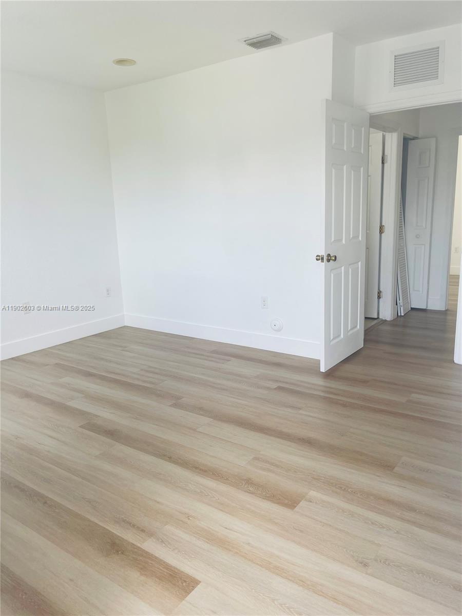 1370 West 30th Street, Unit 1370 Hialeah, FL 33012 - Photo 23 of 23 an empty room with wooden floor