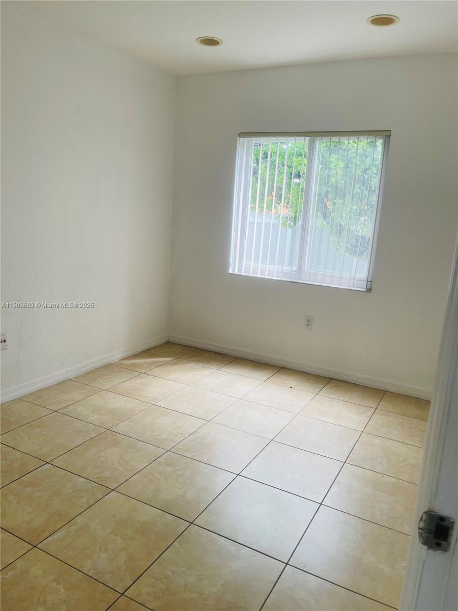 1370 West 30th Street, Unit 1370 Hialeah, FL 33012 - Photo 7 of 23 an empty room with a window