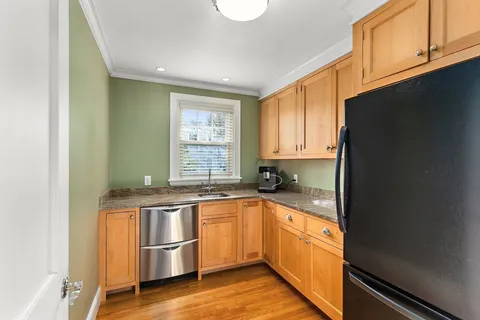 a kitchen with stainless steel appliances granite countertop a sink and a refrigerator