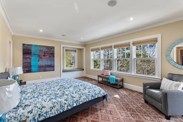 a living room with a couch wooden floor and large windows