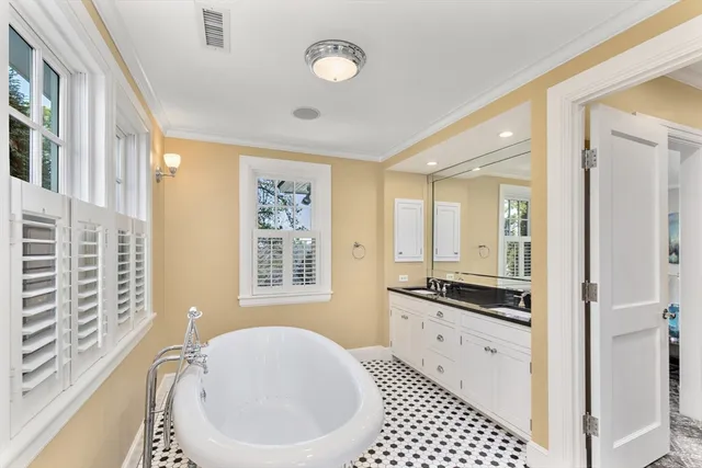 a spacious bathroom with a granite countertop tub a sink and a window
