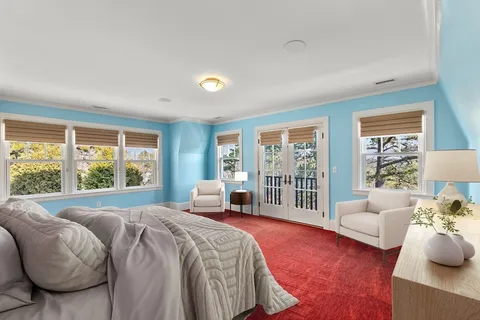 a spacious bedroom with a bed and glass window