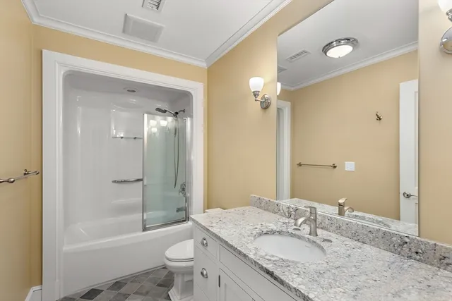 a bathroom with a granite countertop sink a toilet a mirror and shower
