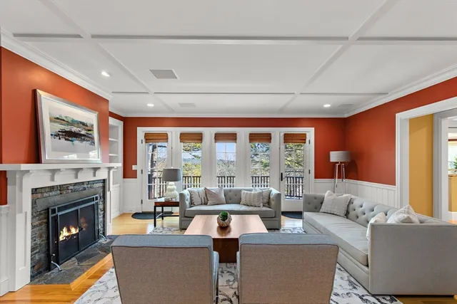 a living room with fireplace furniture and a large window