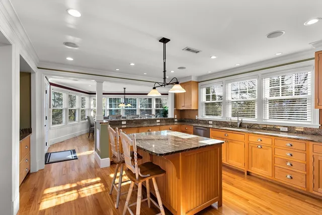 a large kitchen with kitchen island a large window in it