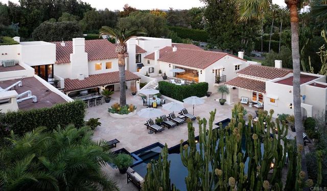an aerial view of residential houses with outdoor space and trees