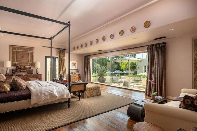 a bedroom with a bed couch and a large window