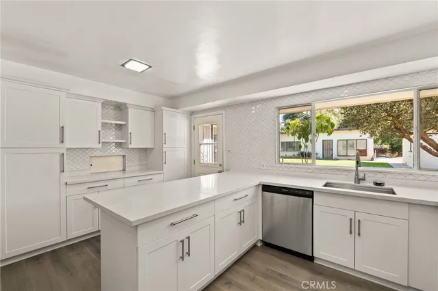 a kitchen with granite countertop a stove a sink and a microwave