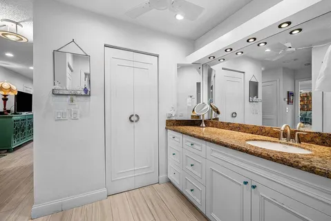 a spacious bathroom with a granite countertop sink mirror and shower