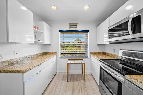 a kitchen with stainless steel appliances granite countertop a stove and a microwave