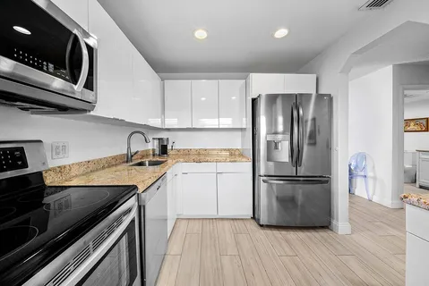 a kitchen with a refrigerator sink and cabinets