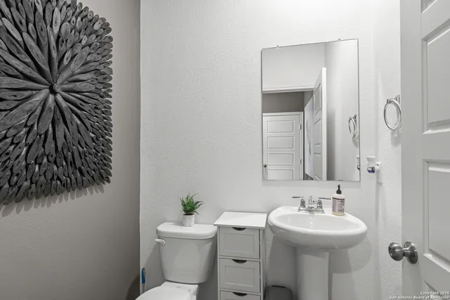 a bathroom with a toilet sink and mirror
