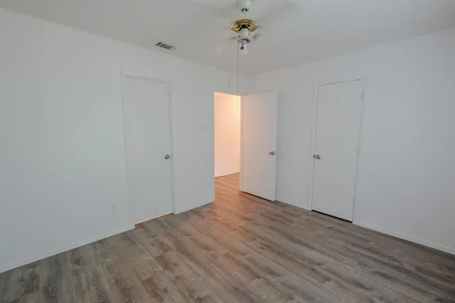 a view of an empty room with wooden floor