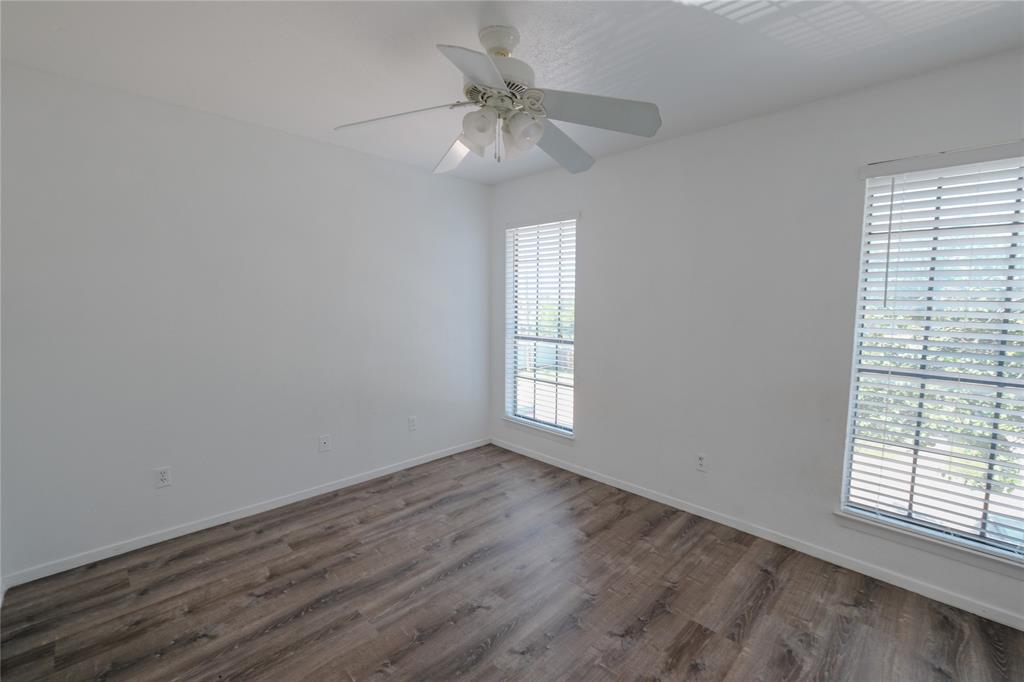 1032 McKinley Street, Unit A Benbrook, TX 76126 - Photo 14 of 14 an empty room with wooden floor fan and windows