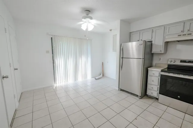 a view of a kitchen with refrigerator and cabinets