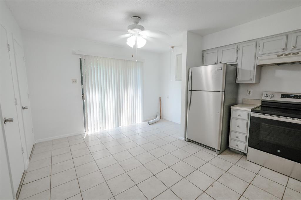 1032 McKinley Street, Unit A Benbrook, TX 76126 - Photo 4 of 14 a view of a kitchen with refrigerator and cabinets