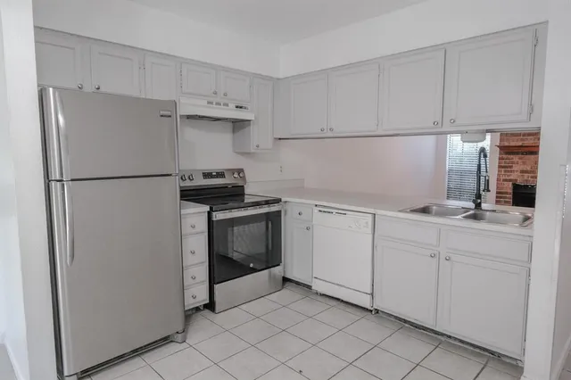 a kitchen with cabinets stainless steel appliances and a sink