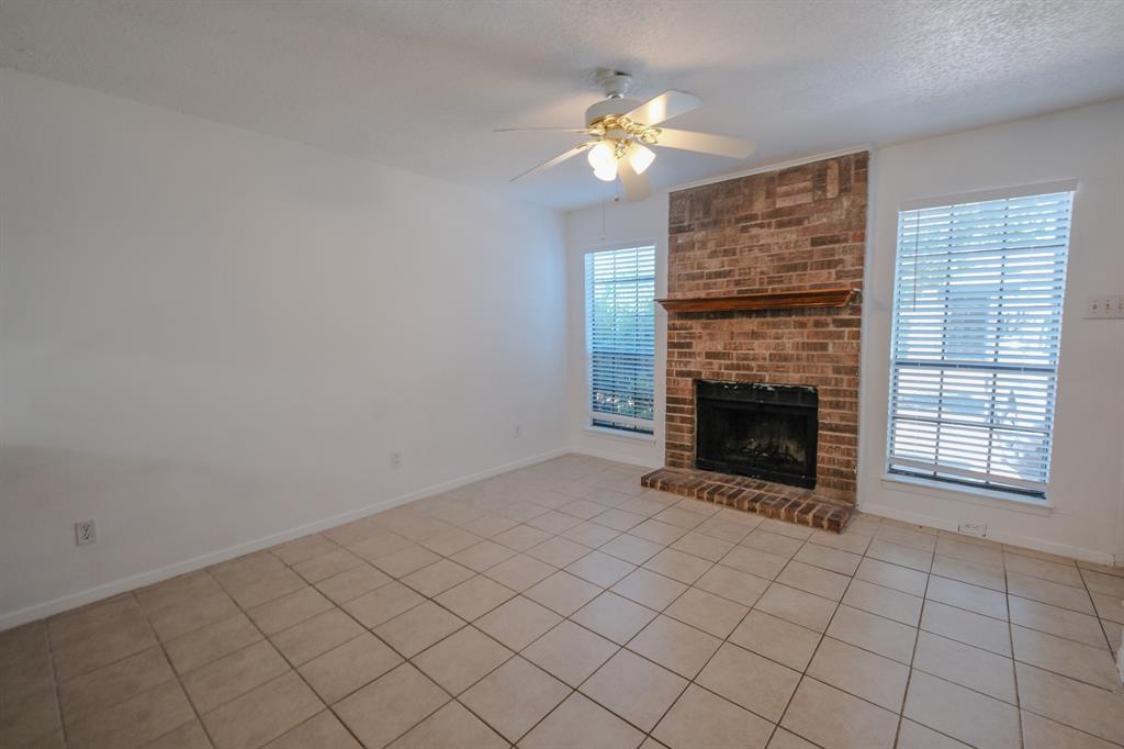 1032 McKinley Street, Unit A Benbrook, TX 76126 - Photo 9 of 14 a view of an empty room with a fireplace and a window