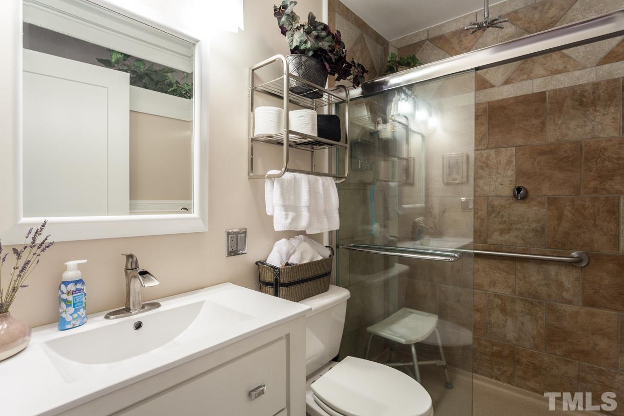 6808 Fairpoint Court Raleigh, NC 27613 - Photo 14 of 16 a bathroom with a sink toilet and shower