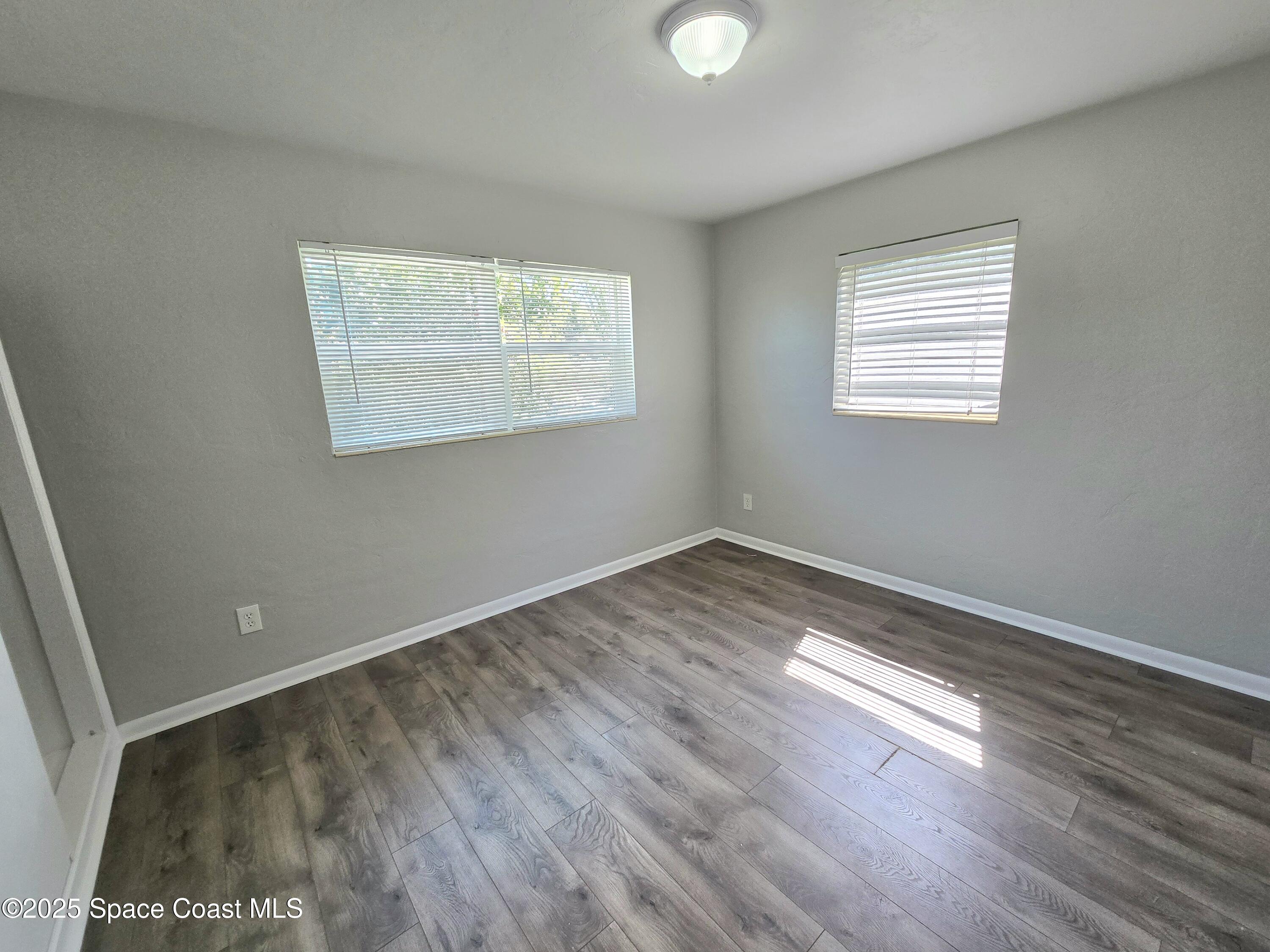 2373 Allan Adale Road Melbourne, FL 32935 - Photo 13 of 19 a view of an empty room with wooden floor and a window