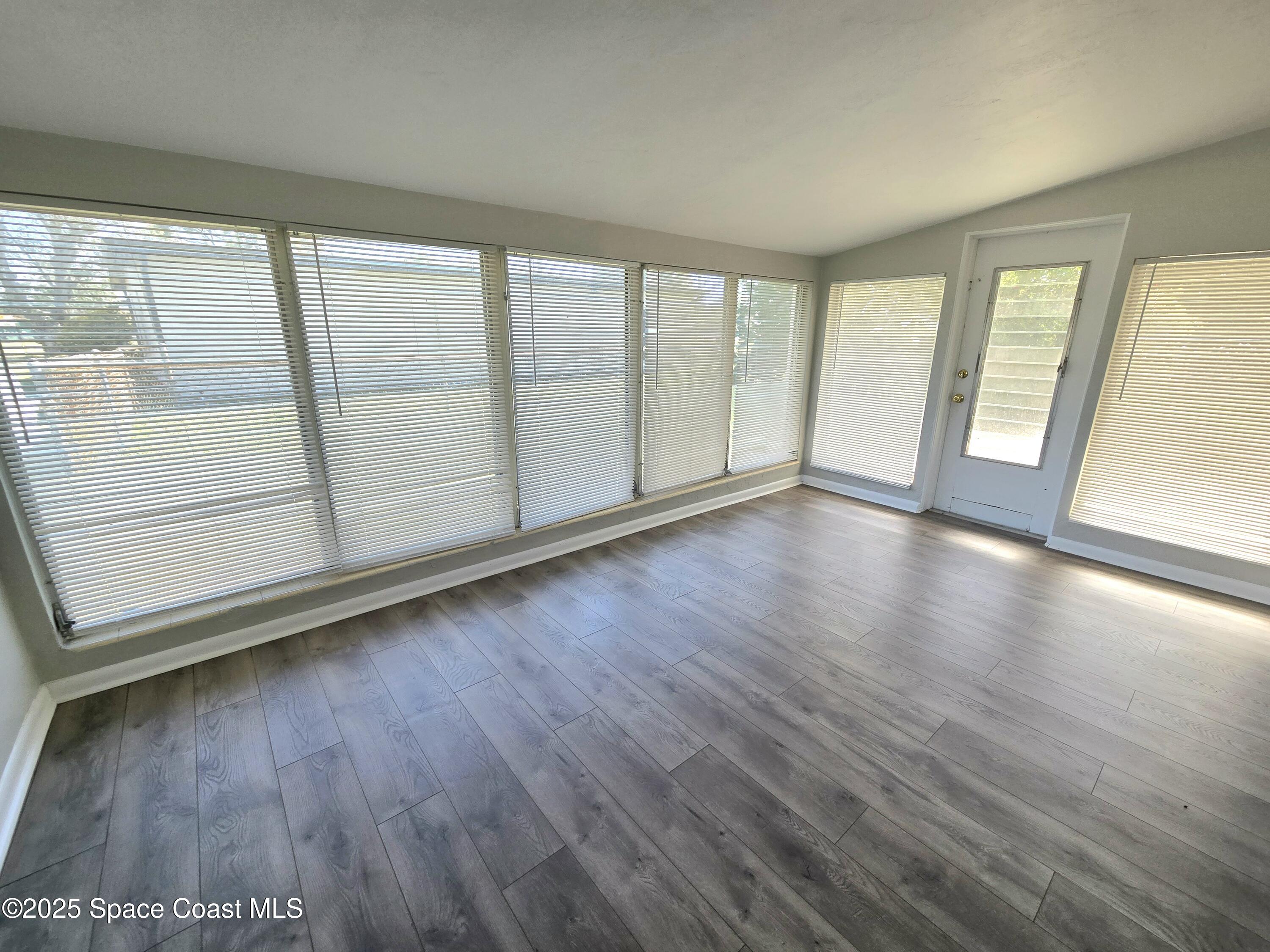 2373 Allan Adale Road Melbourne, FL 32935 - Photo 4 of 19 a view of an empty room with wooden floor and a window