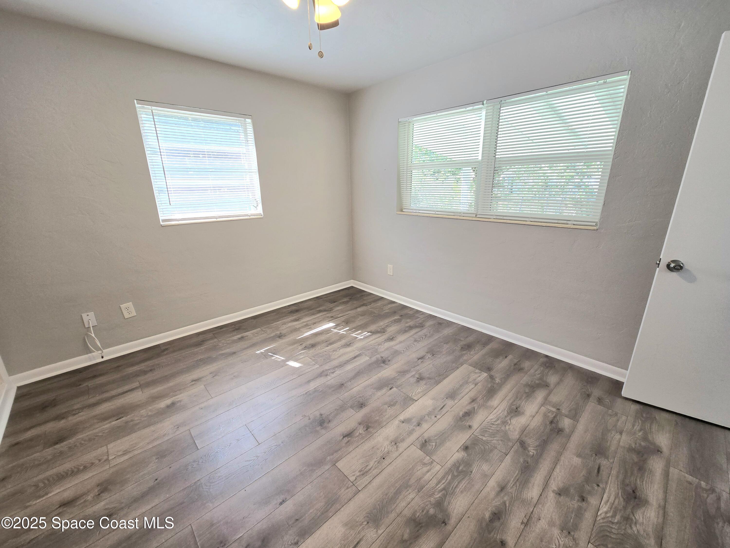 2373 Allan Adale Road Melbourne, FL 32935 - Photo 10 of 19 an empty room with wooden floor and windows