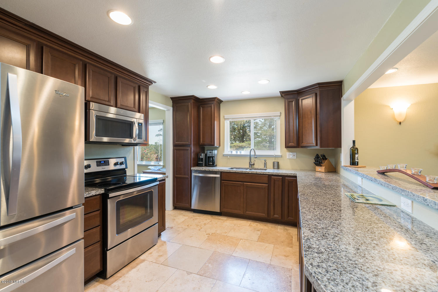 1386 Onstott Road Lompoc, CA 93436 - Photo 10 of 35 a large kitchen with granite countertop a refrigerator stove and oven