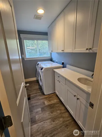 a utility room with cabinets washer and dryer