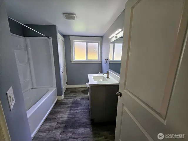 a bathroom with sink shower and mirror