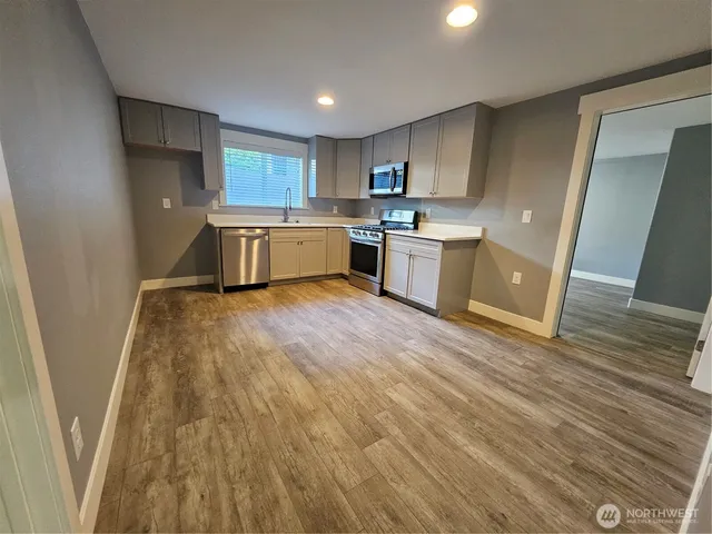 a kitchen with a sink a refrigerator a counter top space and cabinets